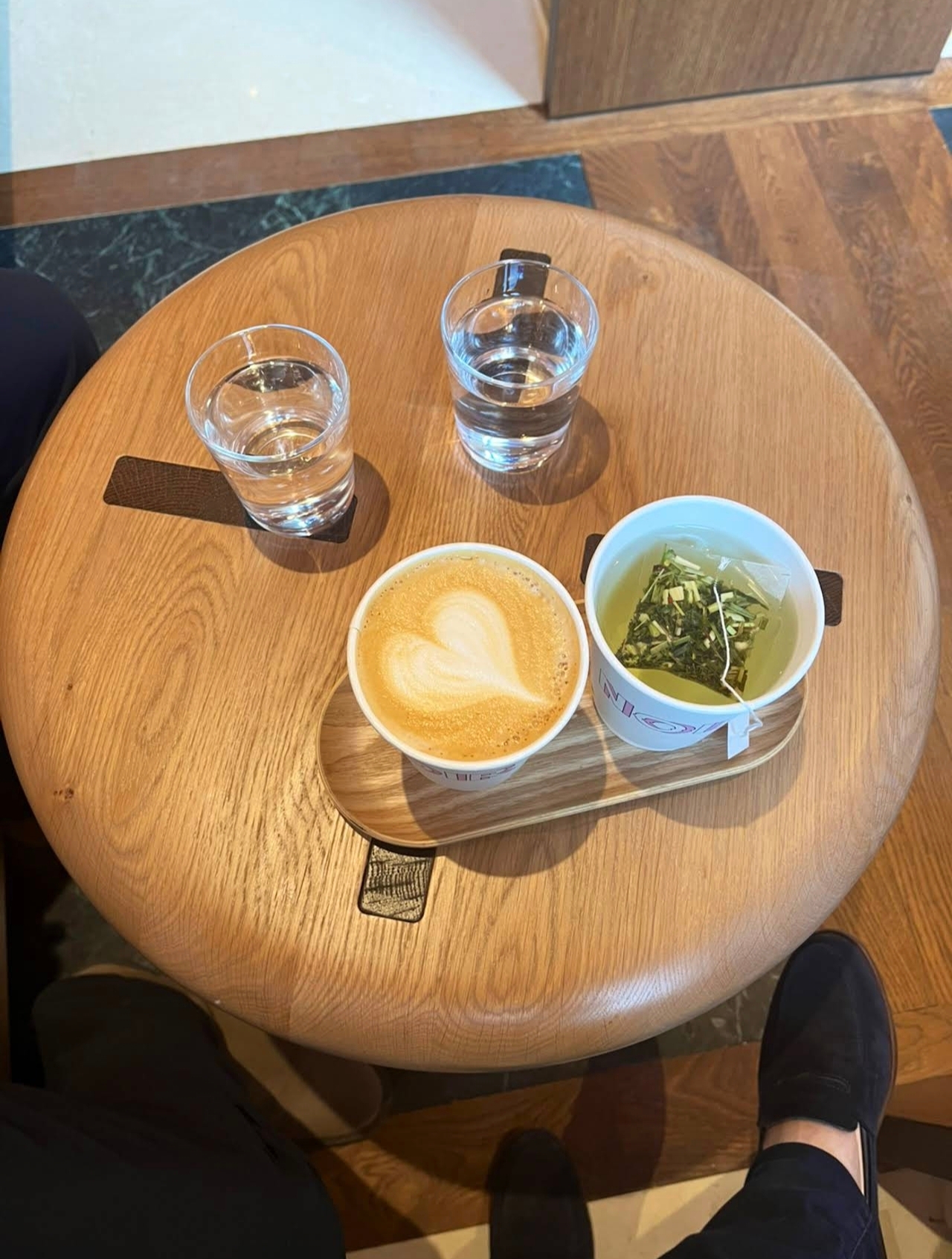 Cappuccino latte art et matcha sur plateau bois chez Noir Coffee