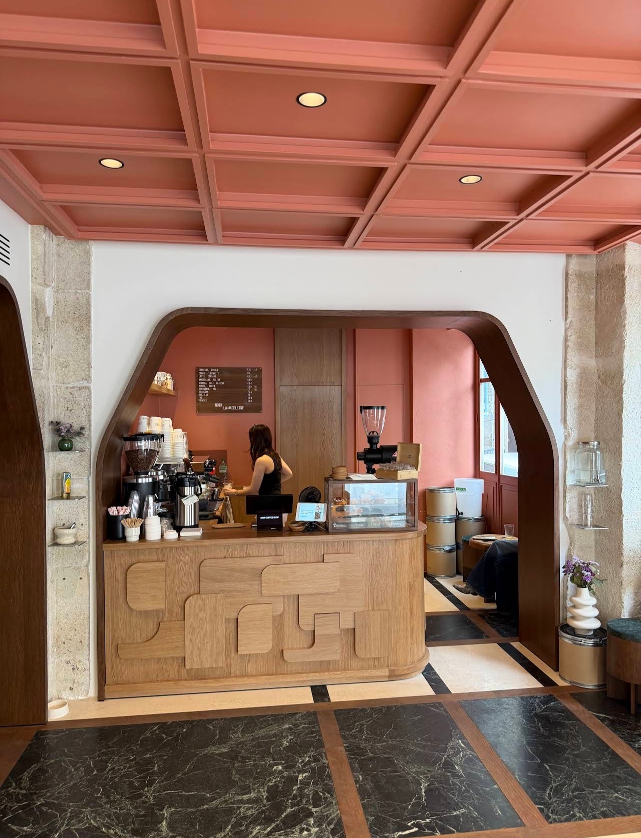Intérieur de Noir Coffee : plafond terre cuite, comptoir en chêne sculpté
